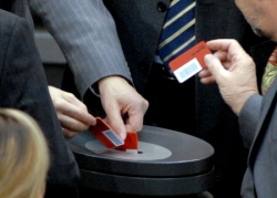 Foto: Detailaufnahme von einer namentlichen Abstimmung im Plenarsaal. Abgeordnete werfen Stimmkarten in Wahlurne