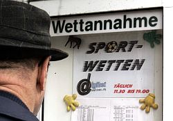 Mann vor Schaukasten einer Wettenannahmestelle in Düsseldorf