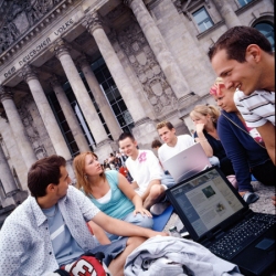 Foto: Jugendliche sitzen mit Laptops vor dem Reichstagsgebäude