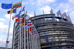 Foto: Gebäude des Europäischen Parlaments, davor Flaggen verschiedener Nationen