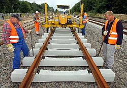 Gleisarbeiter heben Bahnschiene an
