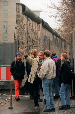 An einem Mauerrest in der Nähe des Potsdamer Platzes informiert sich eine Schulklasse über den Verlauf der ehemaligen Grenzmauer zwischen den beiden Teilen Berlins. Die Reste der früheren Grenzbefestigungen zahlreicher Touristen.