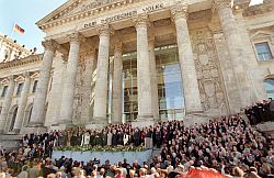 Abgeordnete und Ehrengäste stehen am 19. April 1999 bei der offiziellen Schlüsselübergabe für das Berliner Reichstagsgebäude auf den Stufen und vor dem historischen Bauwerk.