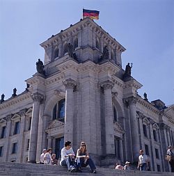 Bâtiment du Reichstag, siège du Bundestag de l'Allemagne réunifiée. Promeneurs assis sur les marches donnant sur la Sprée.
