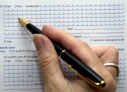 Foto: Nahaufnahme einer Person beim Ausfüllen eines Formulars