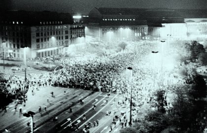 Blick von oben auf eine nächtliche Demonstration durch hell erleuchtete Straßen