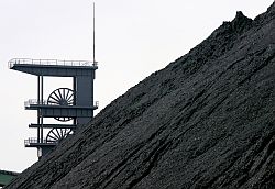 Hinter einer Kohlenhalde steht der Förderturm der Zeche Prosper-Haniel in Bottrop