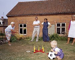 Familie mit Kleinkind im Garten eines Dorfhauses