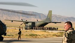 Ein Soldat steht auf dem Flugplatz am Camp Marmal in Masar-i-Sharif im Norden Afghanistans, während andere Soldaten in eine Transall steigen.