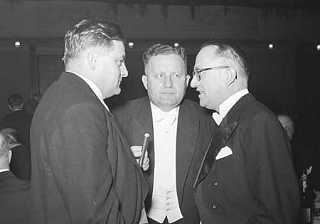 Franz-Josef Strauß, Bundestagsabgeordneter der CSU (l. mit Zigarre), im Gespräch mit Hermann Ehlers, Präsident des Deutschen Bundestages (M.) und Walter Hallstein, Staatssekretär im Auswärtigen Amt, am Rande des Bundespresseballs am 16.11.1952.