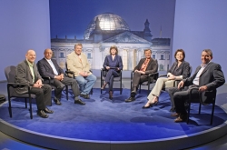 Die Diskussionsteilnehmer sitzen im Halbkreis im Studio des Parlamentsfernsehens