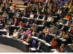 Abgeordnete sitzen im Plenarsaal des Reichstagsgebäudes