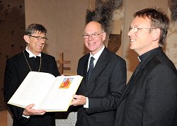 Bundestagspräsident Dr. Norbert Lammert, CDU/CSU, (mitte), nimmt aus den Händen von Prälat Dr. Stephan Reimers, (li.), und Prälat Dr. Karl Jüsten, (re.), die neue Bibel für den Altar im Andachtsraum des Deutschen Bundestages entgegen.