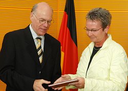 Vorsitzende Naumann (rechts) übergibt den Bericht an Bundestagspräsident Lammert.