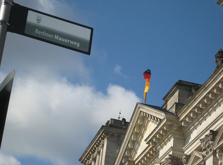 Ein Schild vor dem Reichstagsgebäude zeigt den Berliner Mauerweg an.