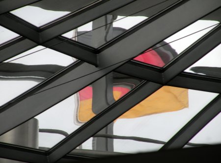 Durch die Kuppel des Reichstagsgebäude ist die Deutschlandfahne sichtbar.