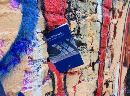 Das Grundgesetz "steckt" in einem bunten Teil der Berliner Mauer.