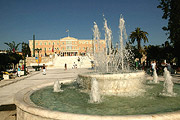 Bild: Helles Geabäude mit einem Springbrunnen im Vordergrund