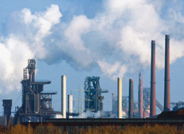 Rauch über Schornsteinschlote eines Industriebetriebs aus der Ferne