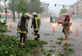 Feuerwehrleute räumen in Kassel die Straße nach einem Wolkenbruch