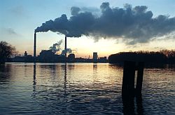 Heizkraftwerk mit Blick auf die Anlage über einen See in der Morgendämmerung