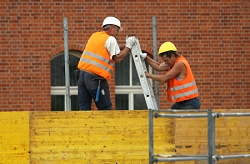 Foto: Arbeiter bauen auf einer Baustelle ein Gerüst auf