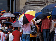 Besucher vor dem Reichstagsgebäude mit bunten Regenschirmen. 