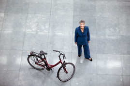 Marieluise Beck neben einem Fahrrad in der Halle des Marie-Elisabeth-Lüders-Hauses.