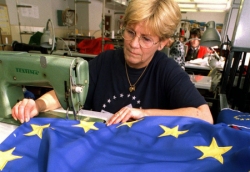 Foto: Näherin einer Flaggenmanufaktur stellet eine europäische Flagge her