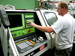 Ein Mitarbeiter einer Getriebebaufirma bedient das Schaltpult eine Maschine