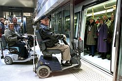 Zwei Rollstuhlfahrer vor geöffneter U-Bahn-Tür, Klick vergrößert Bild