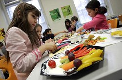 Kinder stellen in einer Berliner Schule geschnittenes Obst zusammen