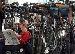 Kameras und Frau die Zeitung liest im Bundestag, Klick vergrößert Bild