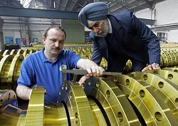 Einen Flansch kontrollieren der Zerspaner Karsten Wölk (l) und der indische Produktionsdirektor Surjit Singh Sethi