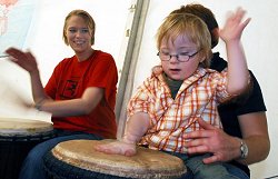 Ein Kind probiert Trommeln aus in einer Begegnungsstätte für Menschen mit und ohne Behinderungen.