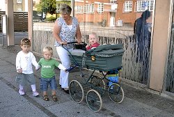 Eine Tagesmutter geht mit drei Kindern spazieren, Klick vergrößert Bild