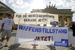 Mitglieder von Amnesty International fordern mit Transparenten vor dem Brandenburger Tor in Berlin einen sofortigen Waffenstillstand im Nahen Osten.
