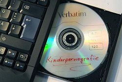 Ein Datenträger mit dem Schriftzug "Kinderpornografie" liegt im Laufwerk eines Notebooks.