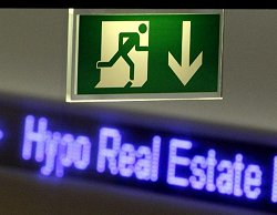 Notausgangsschild vor Schriftzug Hypo Real Estate, Klick vergrößert Bild
