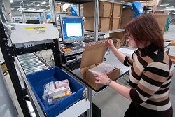 Die Logistikmitarbeiterin kontrolliert die in einem Paket verpackten Arzneimittel.