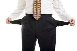 Ein Mann im Anzug zeigt seine leeren Hosentaschen.