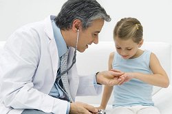Ein Arzt untersucht ein Mädchen in seiner Praxis.