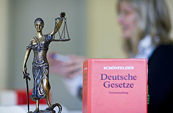 Justitia und ein Buch "Deutsche Gesetze" stehen auf einem Tisch, Klick vergrößert Bild