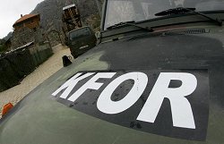 Das von der Bundeswehr bewachte Erzengelkloster, eine Klosteranlage in Prizren im Kosovo, im Vordergrund der Schriftzug KFOR auf der Motorhaube eines Armeefahrzeugs.
