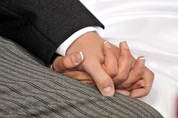 Hochzeit: ein Bräutigam und eine Braut halten sich die Hände.