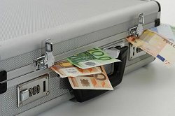 Geldkoffer: aus einem Koffer ragen 50 und 100 Euro-Scheine heraus.