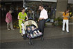 Eine Frau mit Zwillingen im Kinderwagen spricht mit Christian Burholt