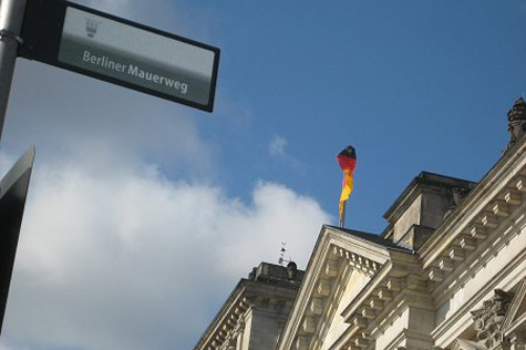 Ein Schild vor dem Reichstagsgebäude zeigt den Berliner Mauerweg an.