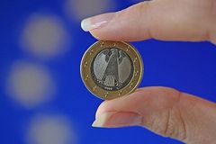 Euro-Münze zwischen zwei Fingern