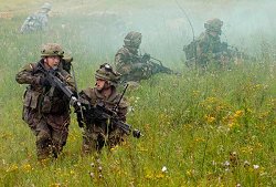 Deutsche Soldaten laufen während einer Übung auf dem Truppenübungsplatz in Hohenfels (Oberpfalz) durch eine Wiese.